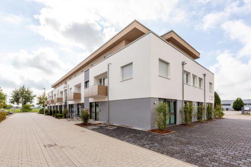 a white building on a cobblestone street at Boardinghouse Hirsch - Apartments in Kork in Kehl am Rhein