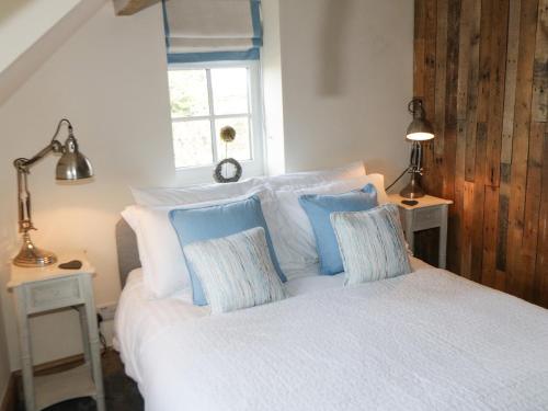 1 dormitorio con 1 cama con almohadas azules y blancas en The Hayshed, en Whitby