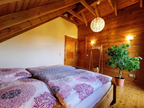 1 dormitorio con 1 cama en una cabaña de madera en Gemütliches Blockhaus am Wald mit großem Garten, en Waltershausen