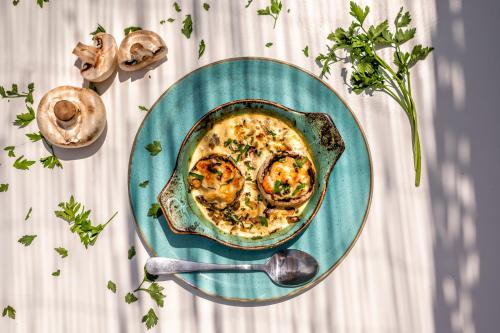a bowl of food on a plate with a spoon at Romantic Palace Beach Apartments in Agios Gordios
