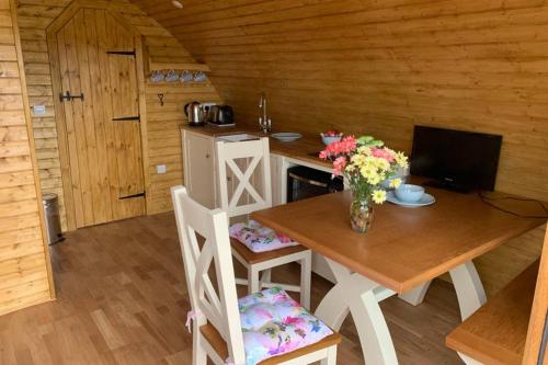 a wooden room with a table with flowers on it at Birdsong Lodge in Woolacombe