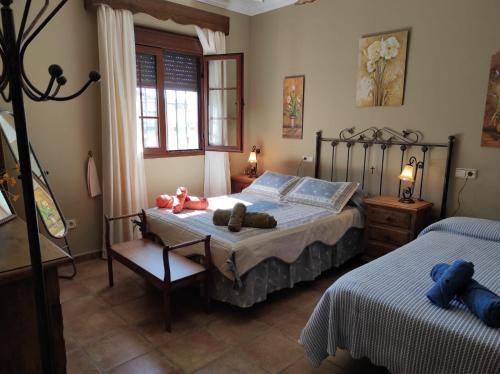 ein Schlafzimmer mit zwei Betten mit ausgestopften Tieren darauf in der Unterkunft LOS ABUELOS in Setenil de las Bodegas