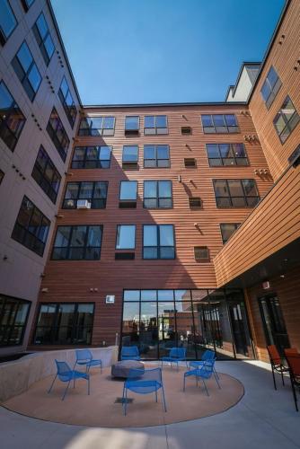 a group of blue chairs in front of a building at Sleepover Premier Downtown Des Moines Apartments in Des Moines