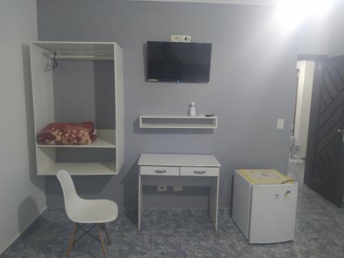 a white desk and a chair in a room at Pousada Elegance Beira Mar in Itanhaém