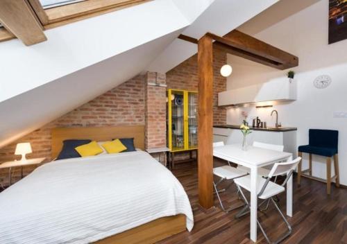 a bedroom with a bed and a table and a kitchen at The Republic Apartments in Prague