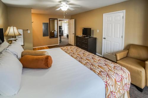 um quarto com uma grande cama branca e um sofá em The Townhouses em Branson