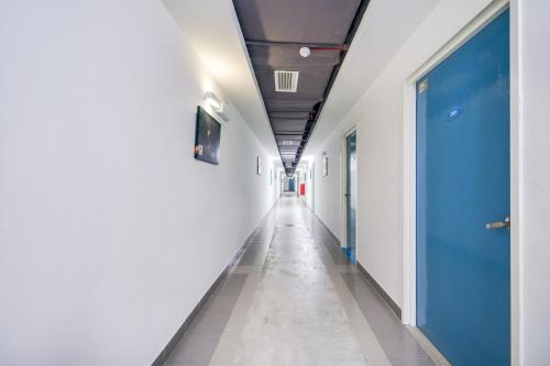 an empty corridor in a hospital with a blue door at Kuala Melaka Inn in Pantai Cenang