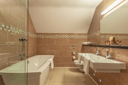 uma casa de banho com uma banheira e um lavatório em Silverbirch Hotel em Omagh