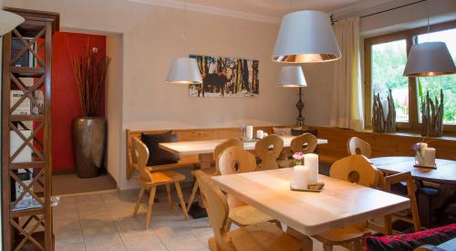 a dining room with tables and chairs and lights at Ferienappartements Landhof in Ellmau