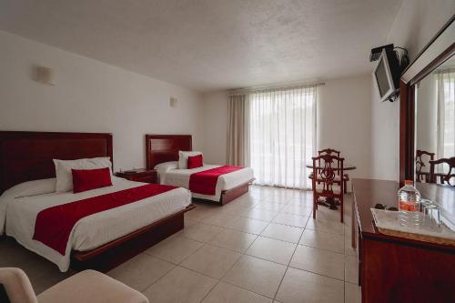 a hotel room with two beds and a television at Hotel Boutique Casa Bella in Yautepec de Zaragoza