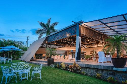 a building with tables and chairs in the grass at Hotel Boutique Casa Bella in Yautepec