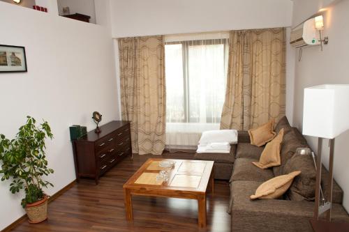a living room with a couch and a table at Hotel Belleville in Iaşi