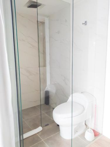 a bathroom with a toilet and a glass shower at Urban Heights Bogota in Bogotá