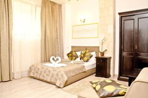 a hotel room with a bed and a chair at Hotel Belleville in Iaşi