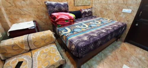Room in Guest room - Posh Foreigners Place,couples Allowed Lajpat Nagar في نيودلهي: منظر علوي لسرير وأريكة في غرفة