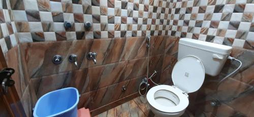 a bathroom with a toilet and a tiled wall at Room in Guest room - Posh Foreigners Place,couples Allowed Lajpat Nagar in New Delhi