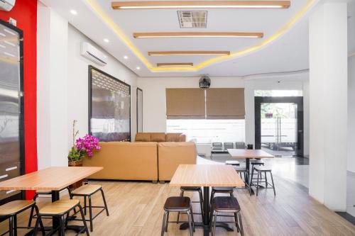 une chambre avec des tables, des chaises et un canapé dans l'établissement Pondok Indah Guest House by ecommerceloka, à Samarinda