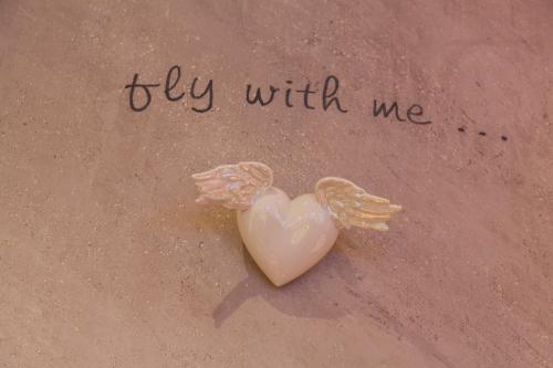 a heart with wings next to the words fly with me at Am Dorfplatz Suites - Adults friendly in Sankt Anton am Arlberg