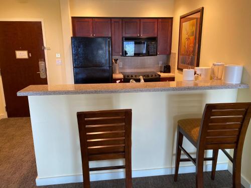 a kitchen with a counter with two chairs and a counter top at Ocean View Luxurious Condo-BEST location + balcony in Destin