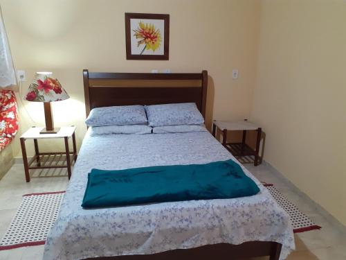 1 dormitorio con 1 cama grande con sábanas azules en Casa Chalé em Penedo en Penedo