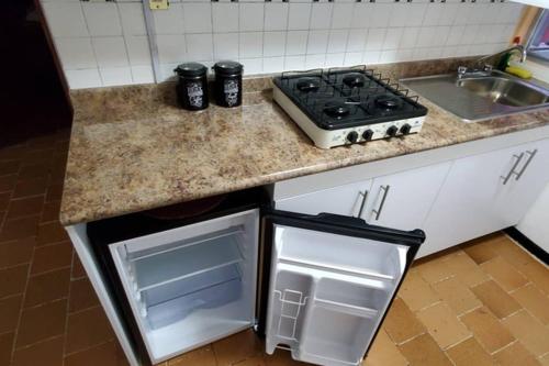 a kitchen with a stove top oven next to a sink at El corazón de Celaya in Celaya