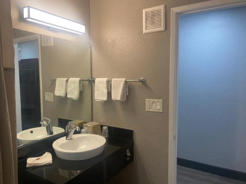 a bathroom with a sink and a mirror at Motel 6-San Bernardino, CA - South in San Bernardino