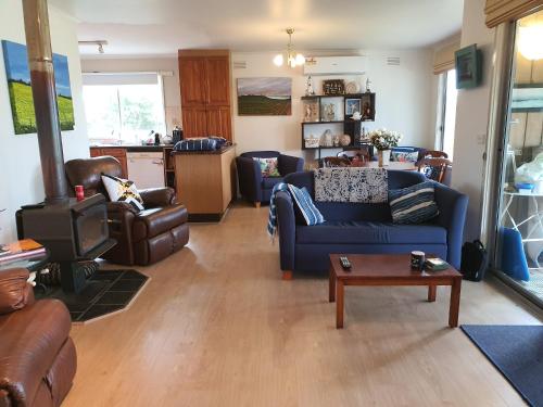 a living room with a blue couch and a table at Little Port Cottage in Portarlington