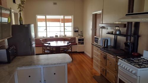 a kitchen with a stove and a table in it at Hillocks Drive in Marion Bay