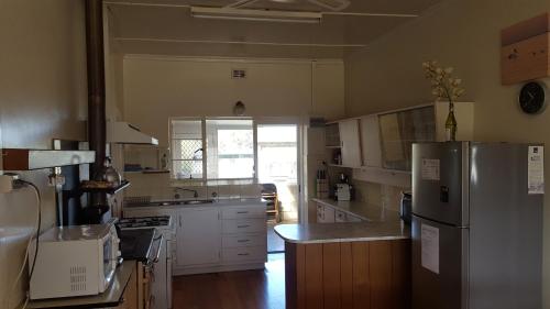 a kitchen with white cabinets and a refrigerator at Hillocks Drive in Marion Bay