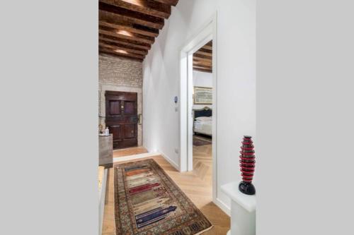 a hallway with white walls and a room with a rug at Appartamento Cassiano Rialto in Venice