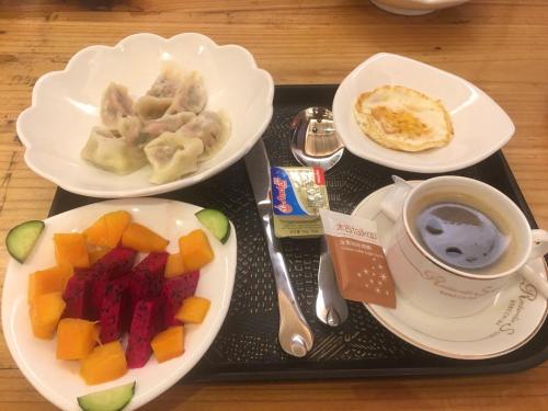 a tray with plates of food and a cup of coffee at Zhangjiajie Highlights Guesthouse in Zhangjiajie