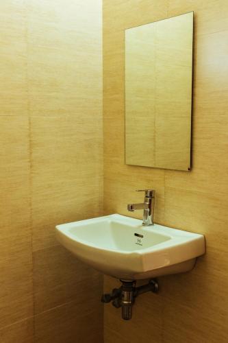 a bathroom with a white sink and a mirror at Hotel Arcadia in Panaji