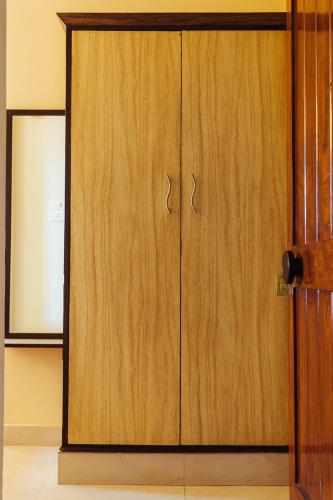 a wooden door with two handles in a room at Hotel Arcadia in Panaji