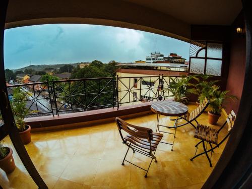 einen Balkon mit einem Tisch und Stühlen sowie Aussicht in der Unterkunft Hotel Arcadia in Panaji