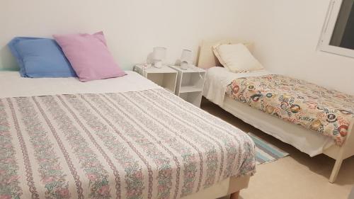 um quarto com duas camas com almofadas em COLOC SUPERGÎTE SPACIEUX PROCHE TOUTES COMMODITÉS em Sauvage