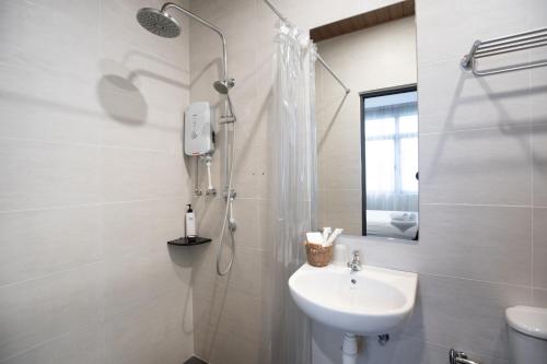 a white bathroom with a sink and a shower at B Street Hotel in George Town