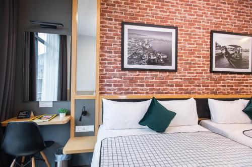 een slaapkamer met een bakstenen muur en een bed bij B Street Hotel in George Town