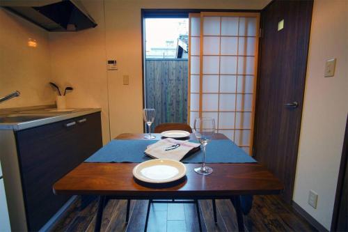 a kitchen with a table with two plates and wine glasses at Inuicho Tori in Kyoto