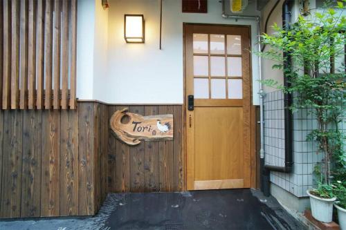 a wooden door to a house with a sign on it at Inuicho Tori in Kyoto