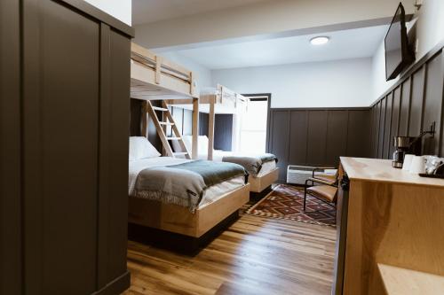 a bedroom with two bunk beds and a desk at The Flying Steamshovel Inn in Rossland