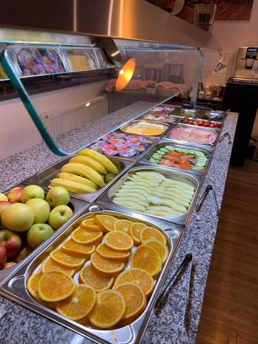 a buffet line with fruits and vegetables and oranges at Hotel Terminal One in Sindelfingen
