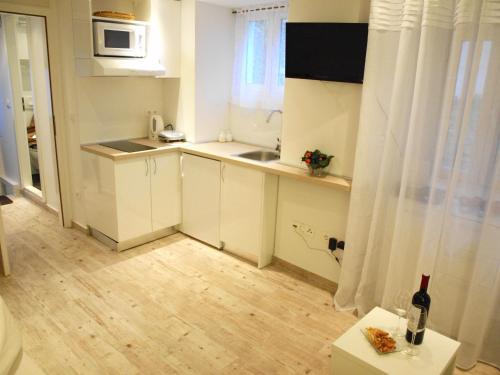 a small kitchen with white cabinets and a sink at Apartment Bonbon in Dubrovnik