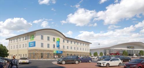 a parking lot with cars parked in front of a building at Holiday Inn Express - Bodmin - Victoria Junction by IHG in Bodmin