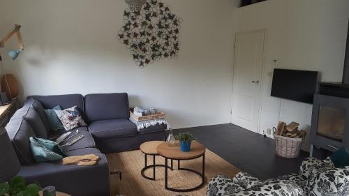 sala de estar con sofá azul y mesa en Zee en Meer, en Kamperland