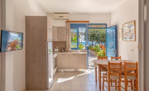 cocina con mesa y sillas y comedor en Akrogiali Studios en Póros Kefalonias