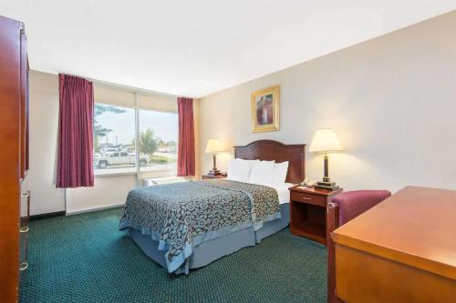 a hotel room with a bed and a desk at Blue Way Inn & Suites Wichita East in Wichita