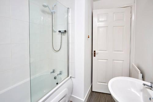 a white bathroom with a shower and a sink at Shirebrook House Coventry west Midlands in Coventry
