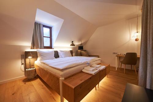 a bedroom with a large bed with a wooden platform at Hotel Plesnik Logarska Dolina in Solčava