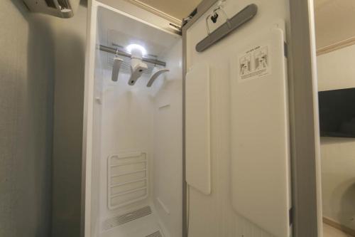 a bathroom with a shower with a door and a light at Goodstay Grand Motel Chuncheon in Chuncheon