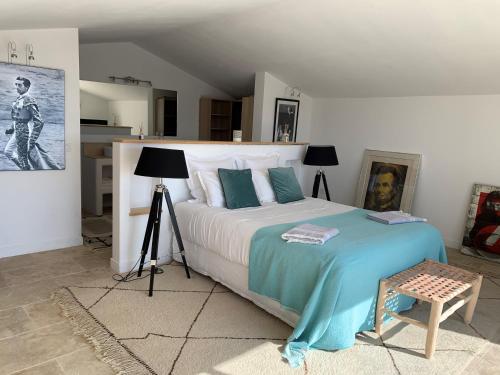 a bedroom with a large bed with blue and white sheets at Maison l'Etrier in Saintes-Maries-de-la-Mer